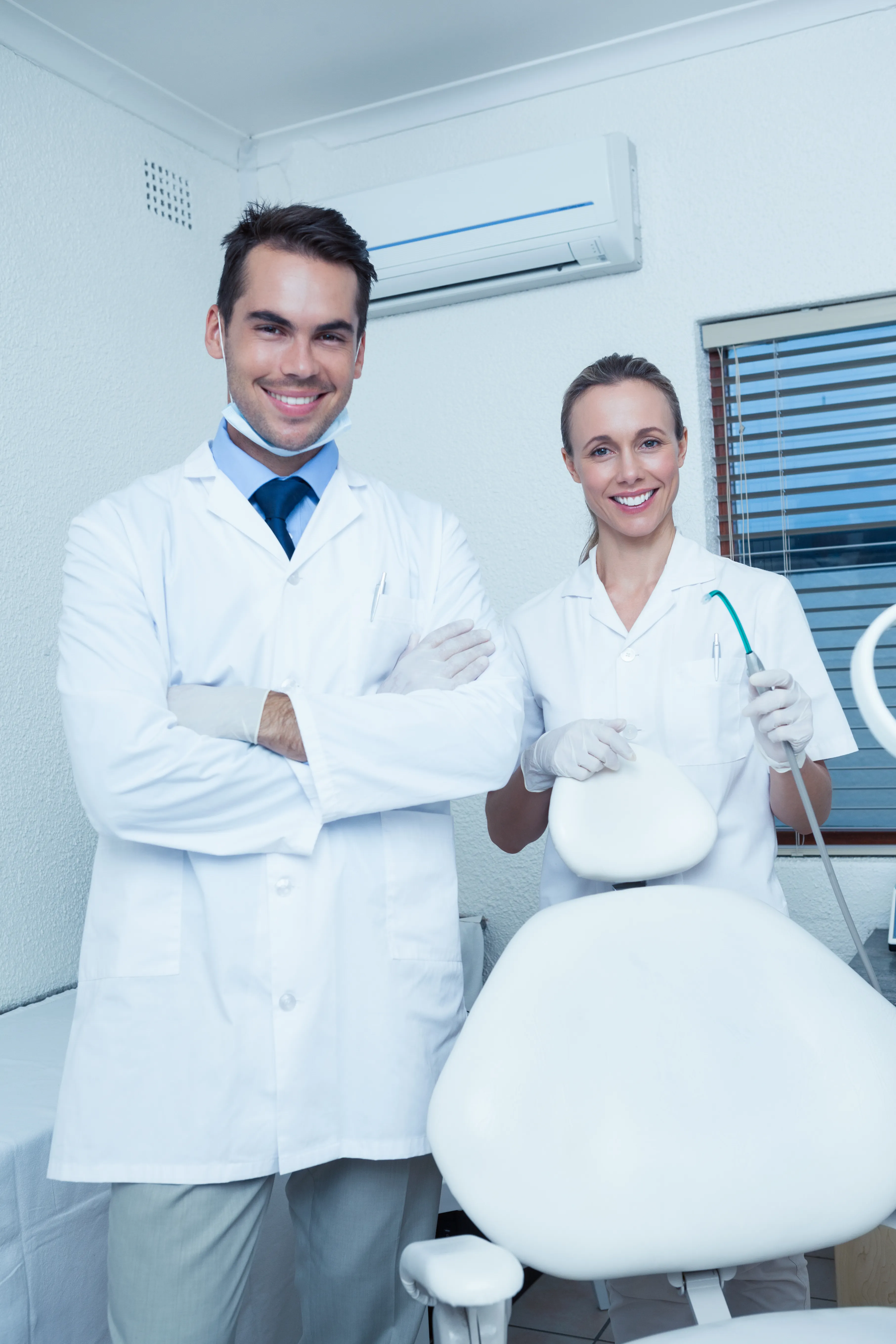 Two smiling oral surgery professionals in a modern clinic